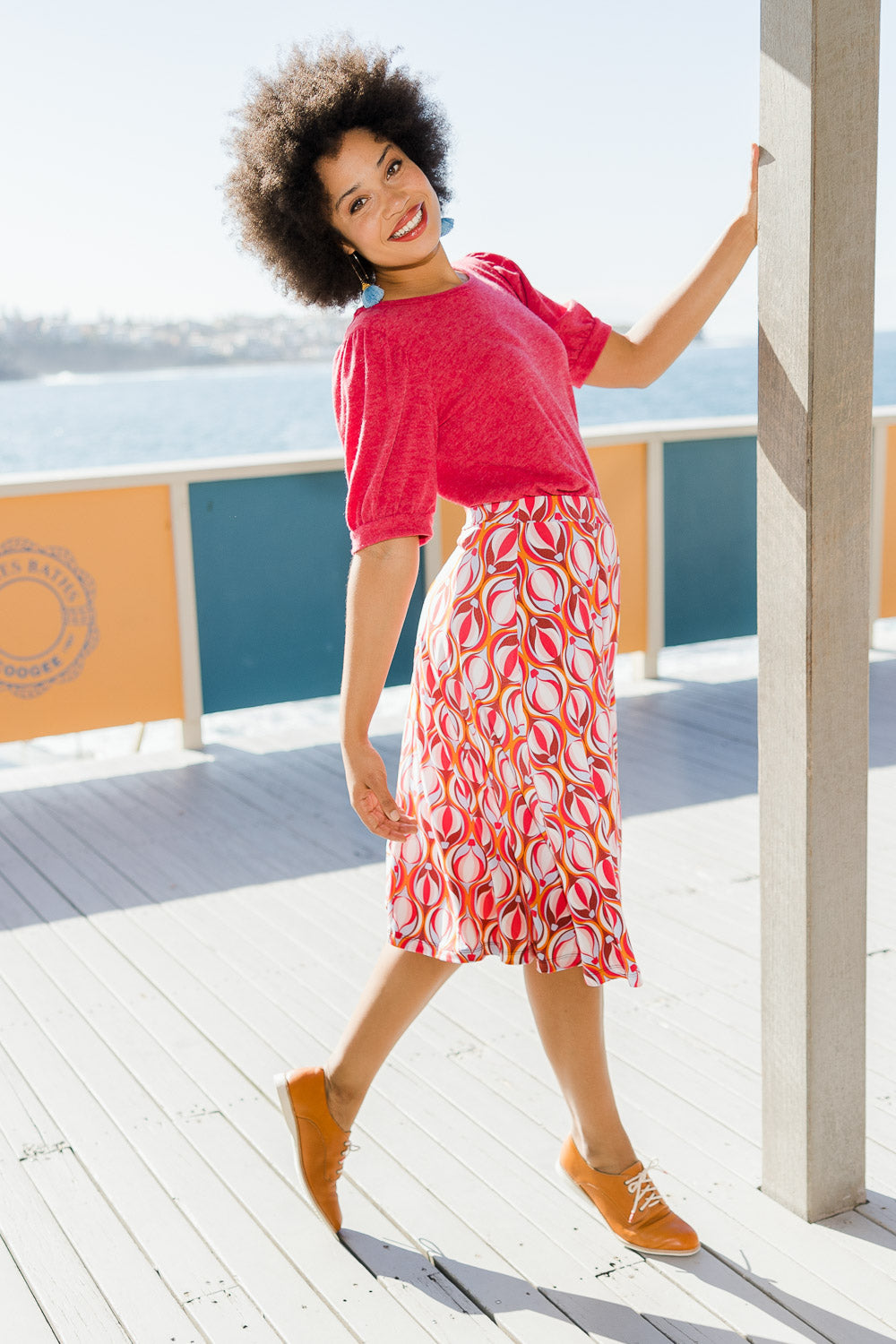 Model Olivia wearing size 10 of the Printed Calf Length Gathered Waist Skirt in colour Balloons (Pink), from the front, showing the whole outfit