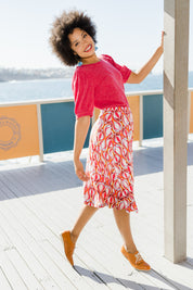 Model Olivia wearing size 10 of the Printed Calf Length Gathered Waist Skirt in colour Balloons (Pink), from the front, showing the whole outfit