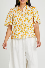 Model Terri-Leigh wearing the Printed Button Thru Blouse in colour Goldfloral, from the front, cropped image