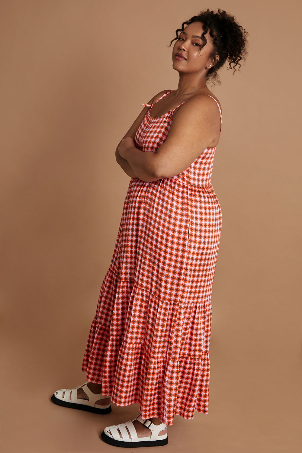 Model Alexis wearing size 16 of the Printed Tiered Maxi Dress in colour Retrostar (Red), from the front, showing the whole outfit