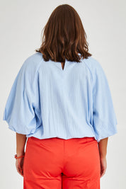 Model Monique wearing size 14 of the Billow Sleeve Top in colour Blue (Blue), from the back