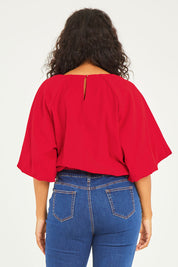 Model Noli wearing size 14 of the Billow Sleeve Top in colour Red (Red), from the back