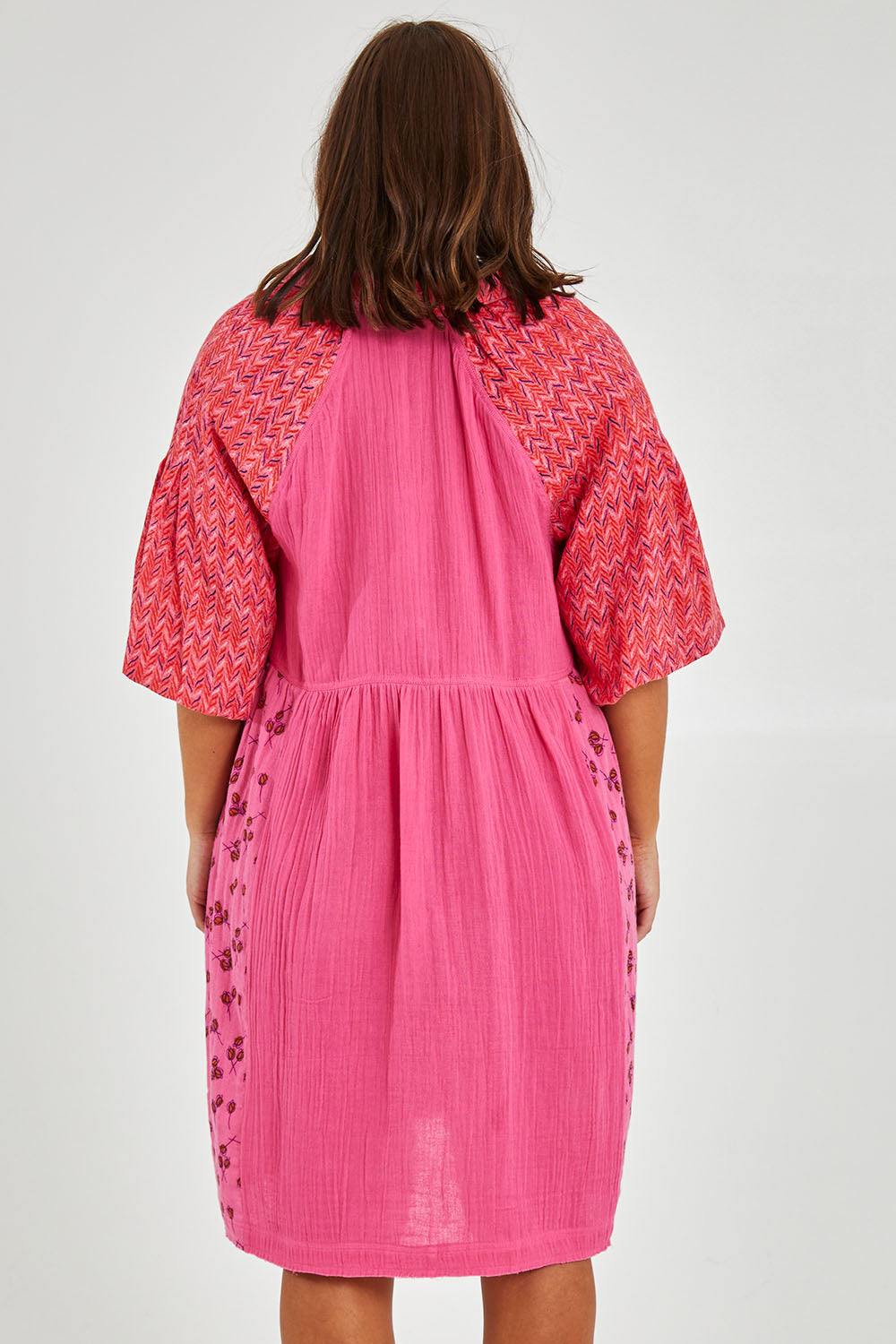 Model Monique wearing size 14 of the Bubble Sleeve Half Placket Dress in colour Mixedpink (Pink), from the back