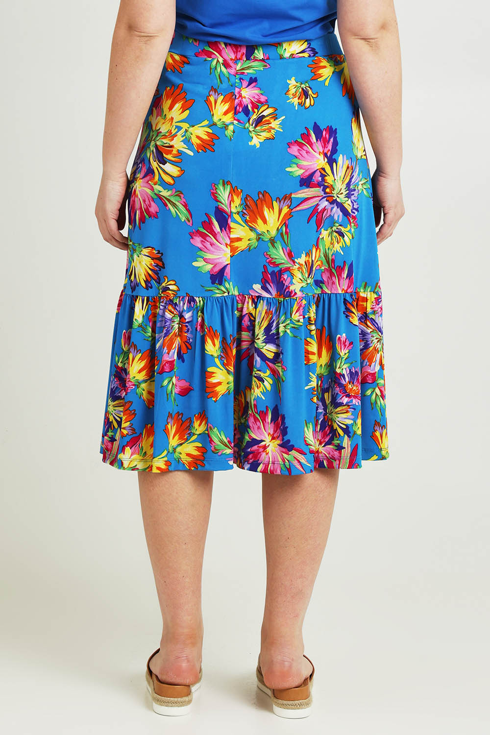 Model Jane wearing size 14 of the Ruffle Skirt in colour Garden (Blue), from the back