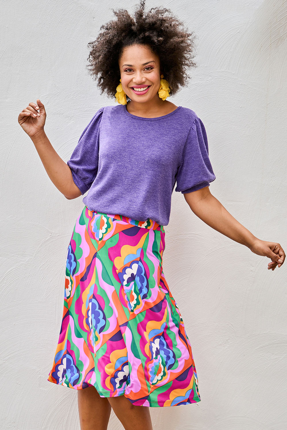 Model Olivia wearing size 10 of the Elastic Waist Skirt in colour Graphic (Purple), from the front, showing the whole outfit