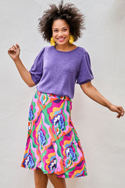 Model Olivia wearing size 10 of the Elastic Waist Skirt in colour Graphic (Purple), from the front, showing the whole outfit