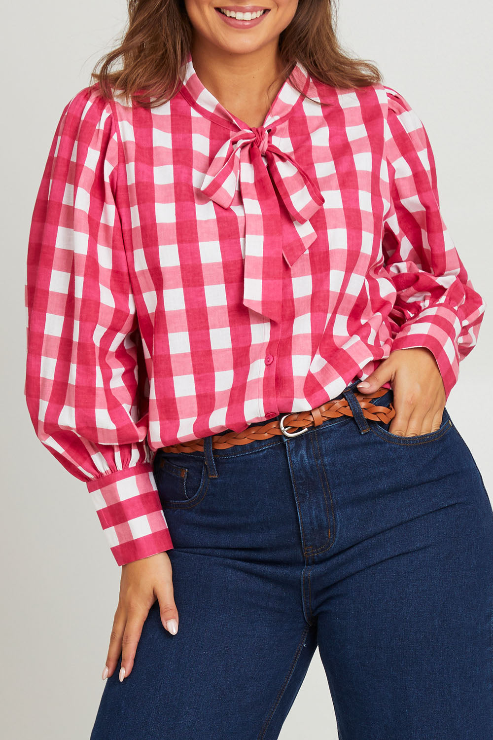 Model Monique wearing size 14 of the Printed Tie Neck Blouse in colour Berrycheck (Pink), from the front, cropped image