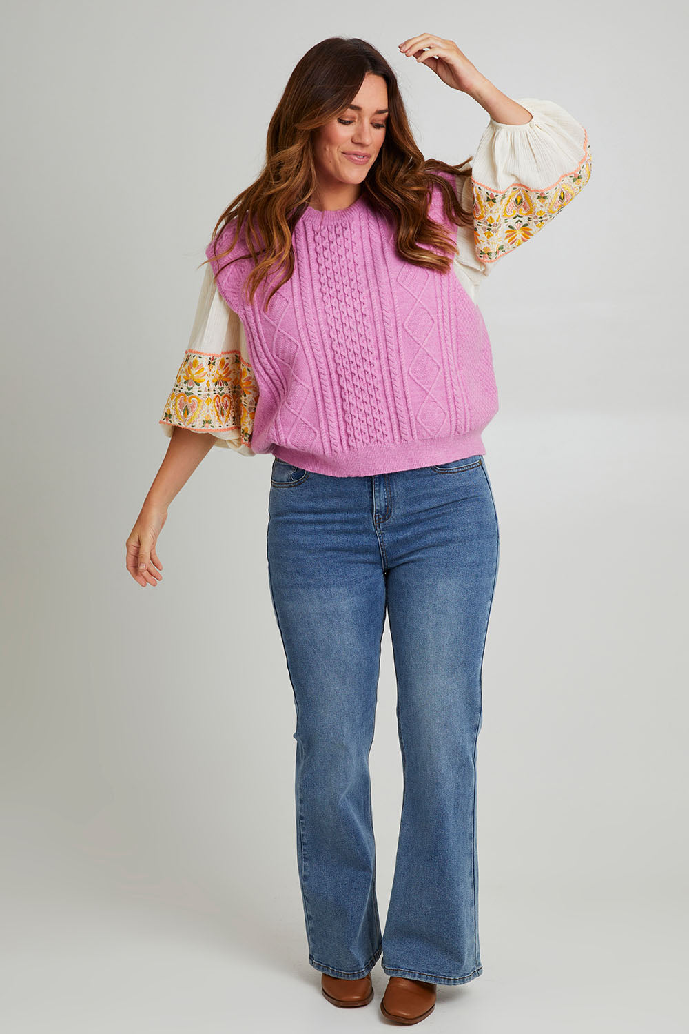 Model Laura wearing the Cable Vest in colour Cable (Pink), from the front, showing the whole outfit