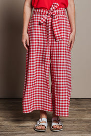 Model Katie wearing size 10 of the Cotton Waist Tie Pants in colour Ginghamred (Red), from the front, cropped image