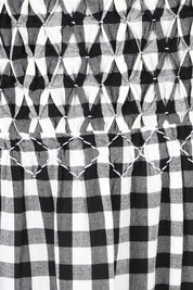 Product shot of the Smocked Tiered Cotton Dress in colour Gingham (Black), detail