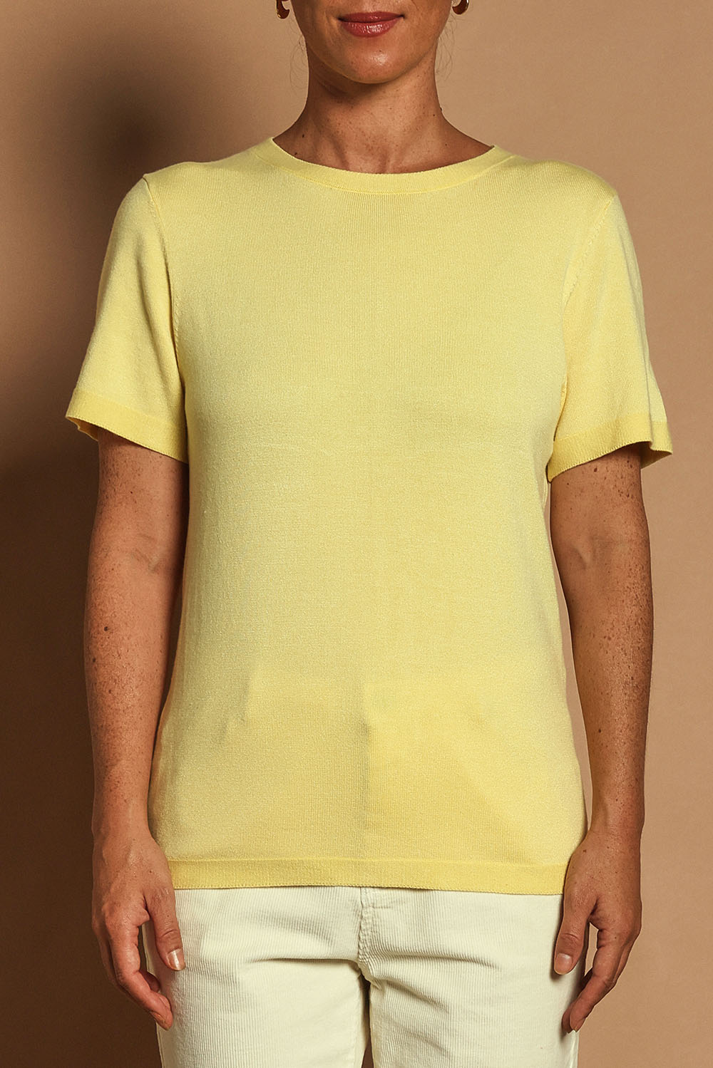 Model Katie wearing size S of the Short Sleeve Knit Top in colour Yellow, from the front, cropped image