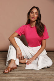 Model Madeline wearing size 10 of the Mercerised Cotton Frill Top in colour Pinkrose (Pink), from the front, showing the whole outfit