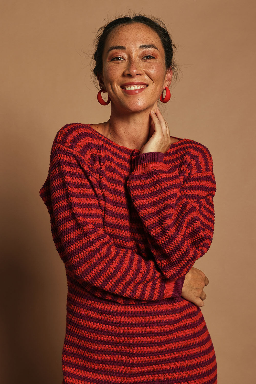 Model Katie wearing size S of the Cotton Stripe Knit Dress in colour Redpurple (Red), from the front, cropped image