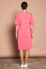 Model Katie wearing size 10 of the Cotton Jersey Puff Sleeve Dress in colour Coralpink (Pink), from the back