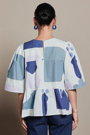 Model Katie wearing size 10 of the Cotton Tiered Blouse in colour Abstract (Blue), from the back