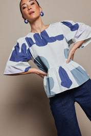 Model Katie wearing the Cotton Tiered Blouse in colour Abstract (Blue), from the front, cropped image