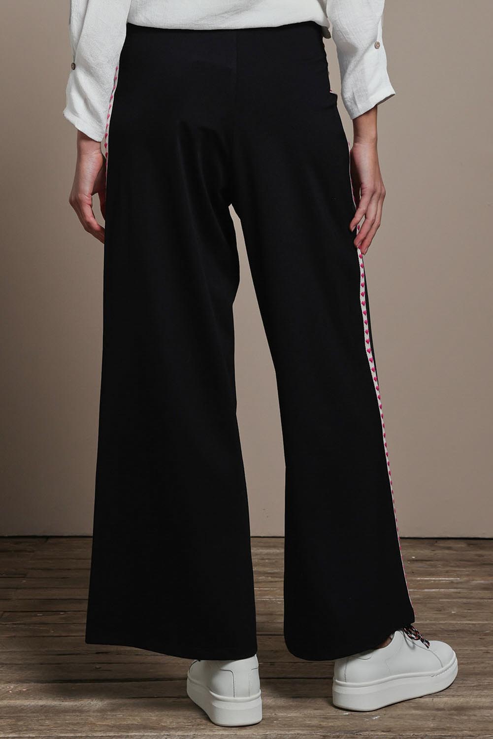 Model Madeline wearing size 10 of the Love Trim Pants in colour Black (Black), from the back