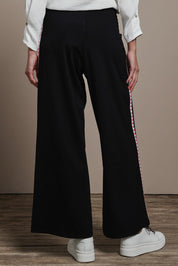 Model Madeline wearing size 10 of the Love Trim Pants in colour Black (Black), from the back