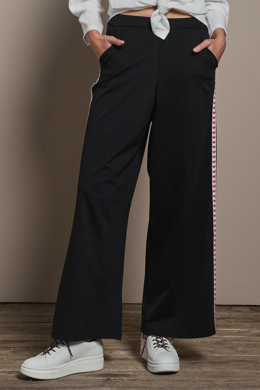 Model Madeline wearing size 10 of the Love Trim Pants in colour Black (Black), from the front, cropped image