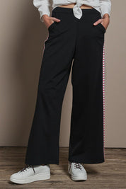 Model Madeline wearing size 10 of the Love Trim Pants in colour Black (Black), from the front, cropped image