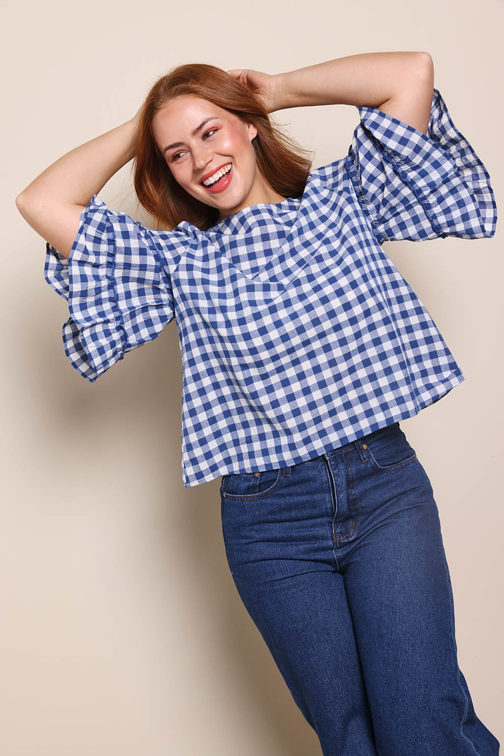 Model Georgiel wearing size 10 of the Cotton Gingham Frill Blouse – Blue in colour Blue, from an angle
