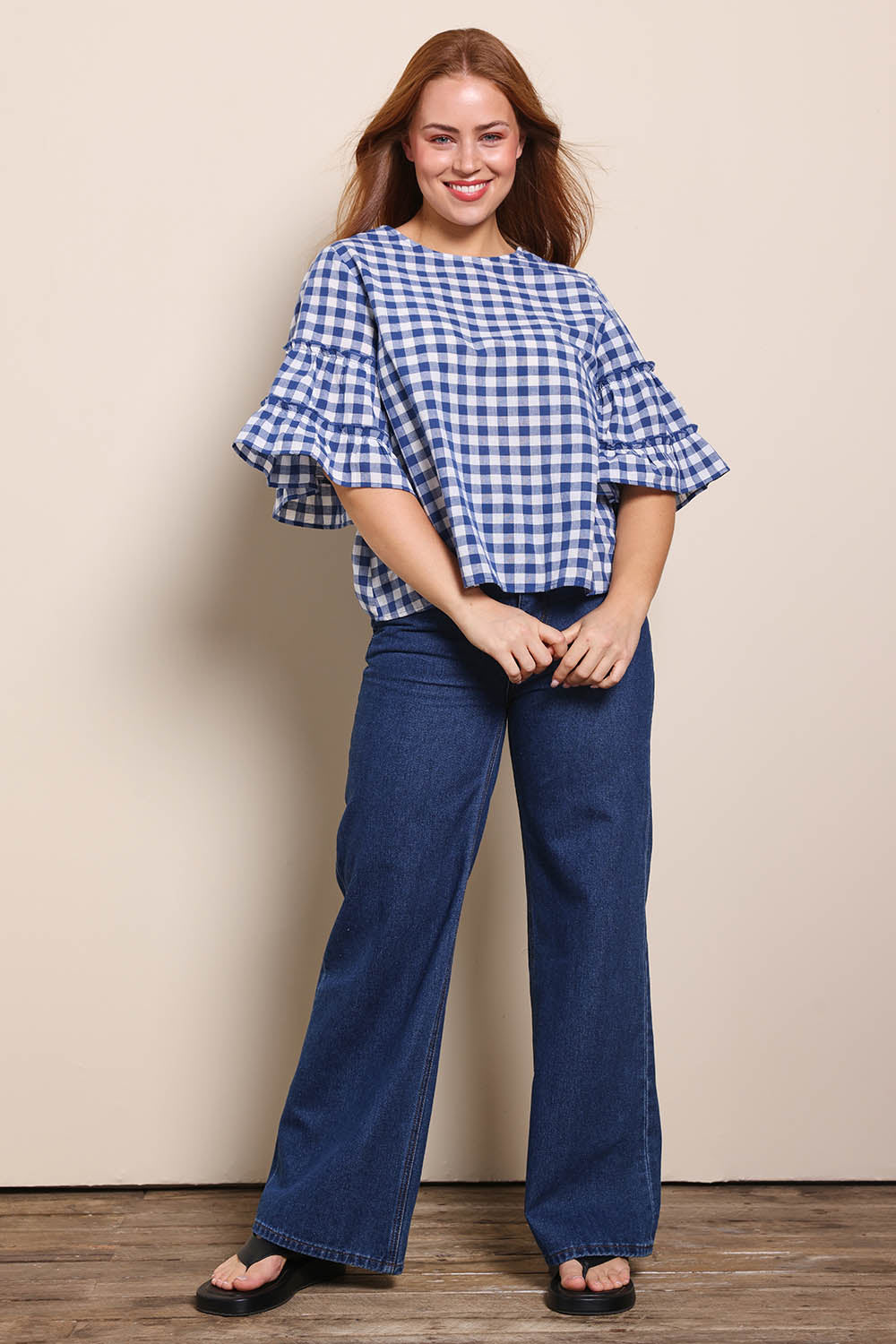 Model Georgiel wearing size 10 of the Cotton Gingham Frill Blouse – Blue in colour Blue, from the front