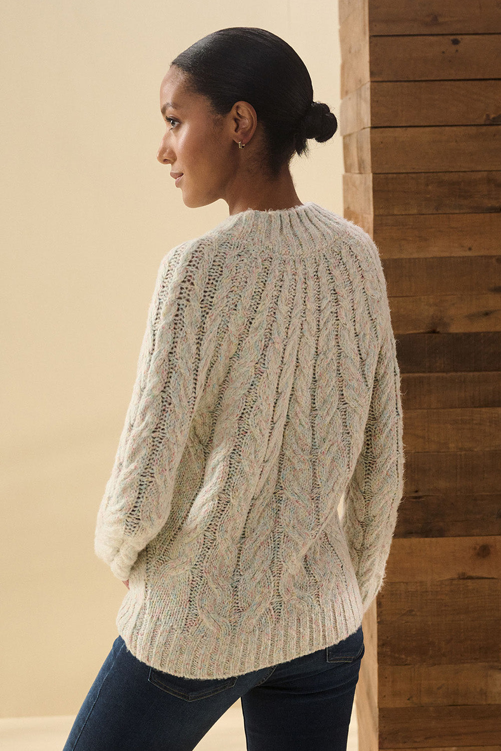 A model wearing the Dylan Cable Knit Sweater in colour Rainbow, from the back