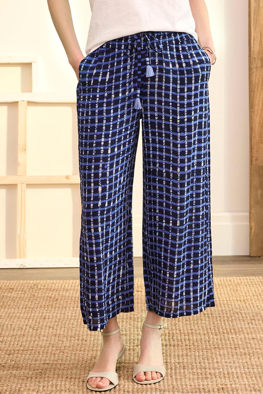 A model wearing the Cassie Pants in colour Plaid (Blue), from the front, cropped image