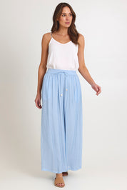 Model Madeline wearing size S of the Baja Pant in colour Safira (Blue), from the front, showing the whole outfit