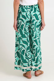 Model Madeline wearing size S of the Santos Cotton Pant in colour Amazon (Green), from the back