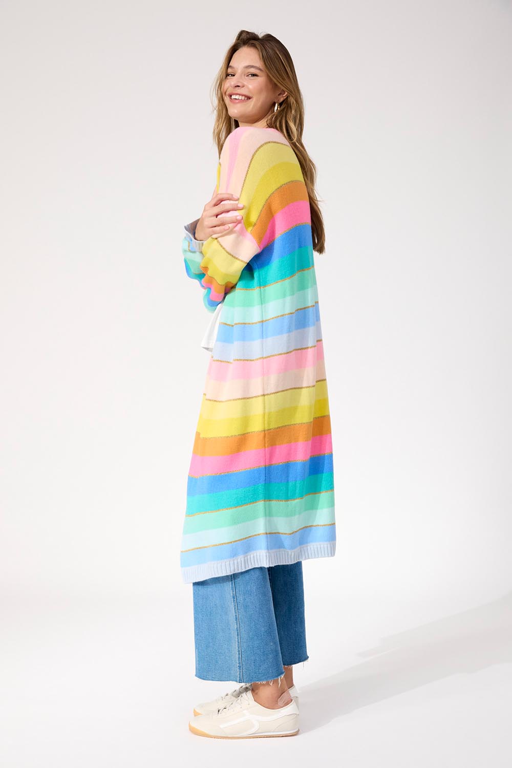 A model wearing the Niseko Cardigan in colour Pastel, from the front, showing the whole outfit