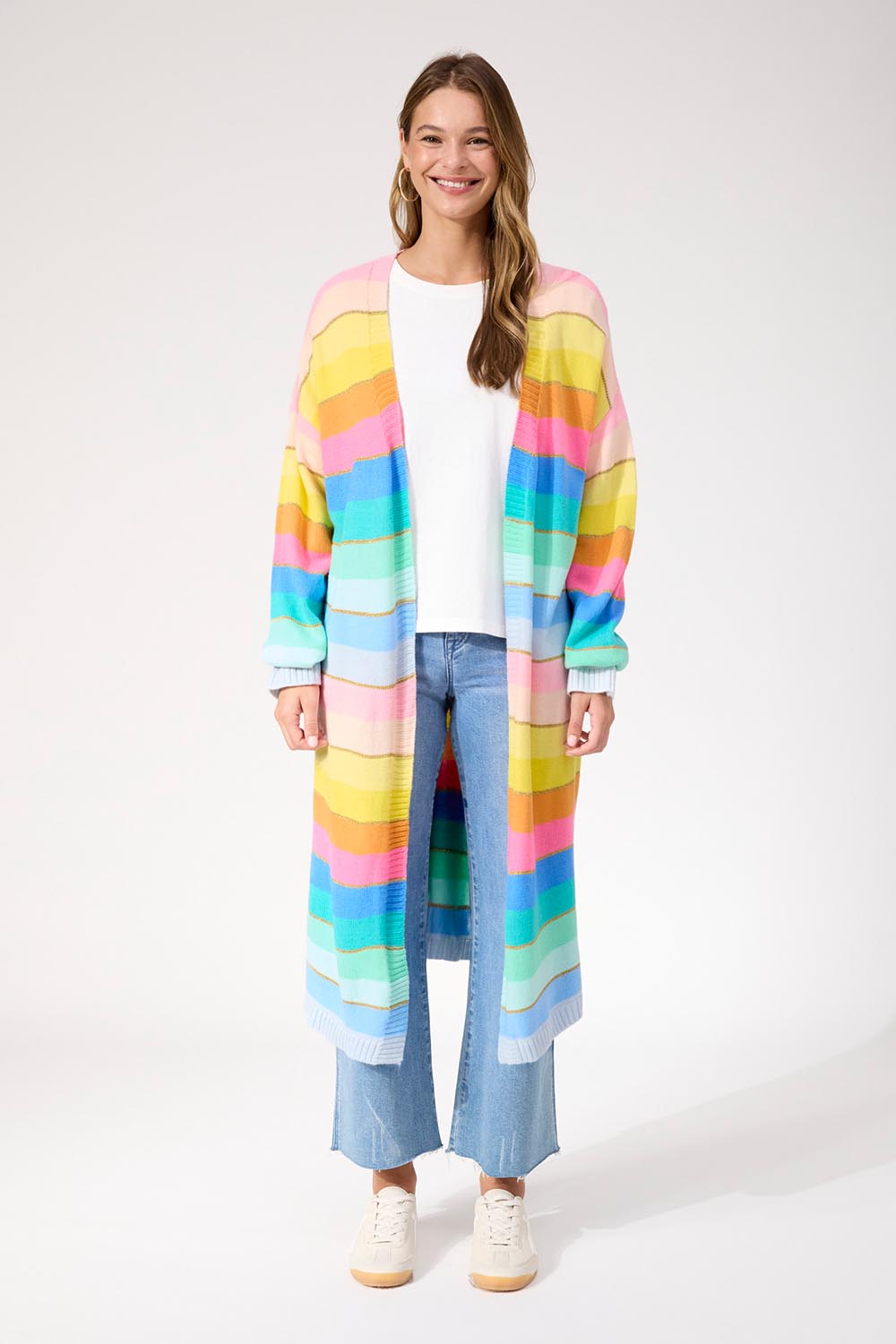 A model wearing the Niseko Cardigan in colour Pastel, from the front, showing the whole outfit