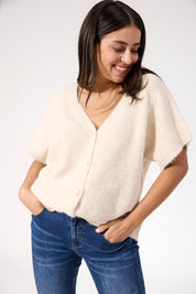 A model wearing the Valenza Knit Vest in colour Natural, from the front, cropped image