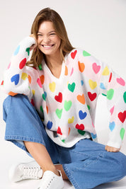 A model wearing the Alaska Relaxed Heart Jumper in colour Rainbow, from the front, cropped image