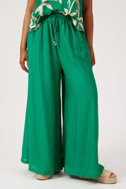 Model Genericm wearing size sample of the Kenya Palazzo Pant – Green in colour Green, in a cropped view
