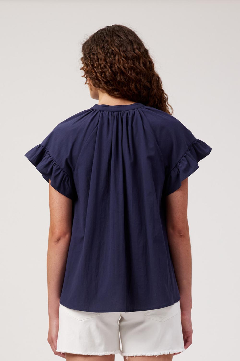 Model Genericm wearing size sample of the Crete Top – Navy in colour Navy, from the back