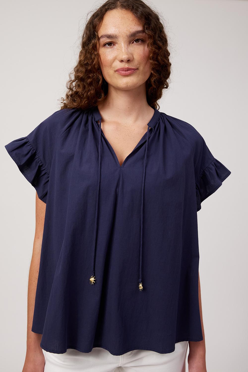 Model Genericm wearing size sample of the Crete Top – Navy in colour Navy, in a cropped view