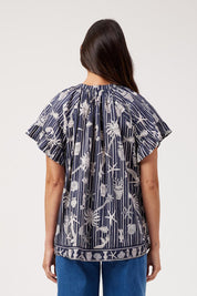 Model Genericm wearing size sample of the Crete Top – Sea in colour Sea, from the back