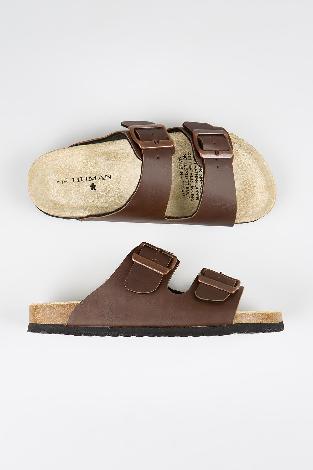 Model Genericm wearing size sample of the Ibiza Slide - Chocolate in colour Chocolate, from an angle