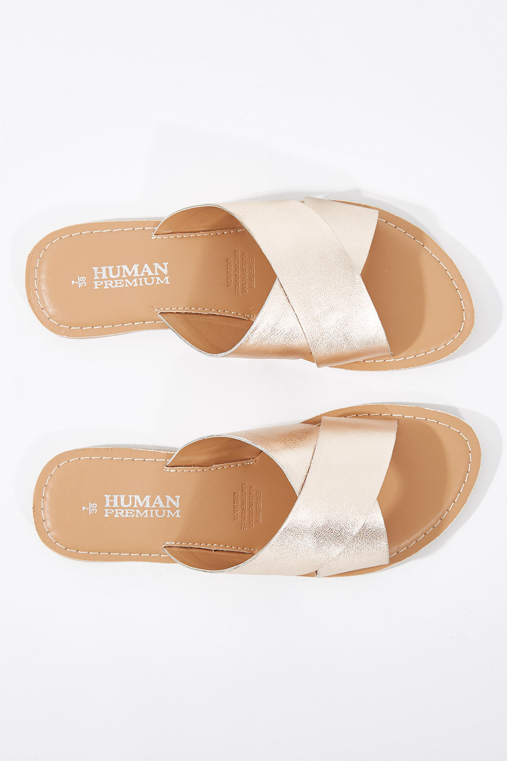 A model wearing size 38 of the Quinn Leather Sandal in colour Rosegold (Metallics), from the front, showing the whole outfit