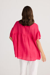 A model wearing the Caicos Linen Top in colour Raspberry (Blue), from the back