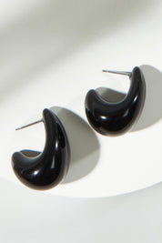 A model wearing the Gina Earrings in colour Black (Black), from the front, showing the whole outfit