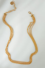 A model wearing the Leo Necklace in colour Gold (Metallics), from the front, showing the whole outfit