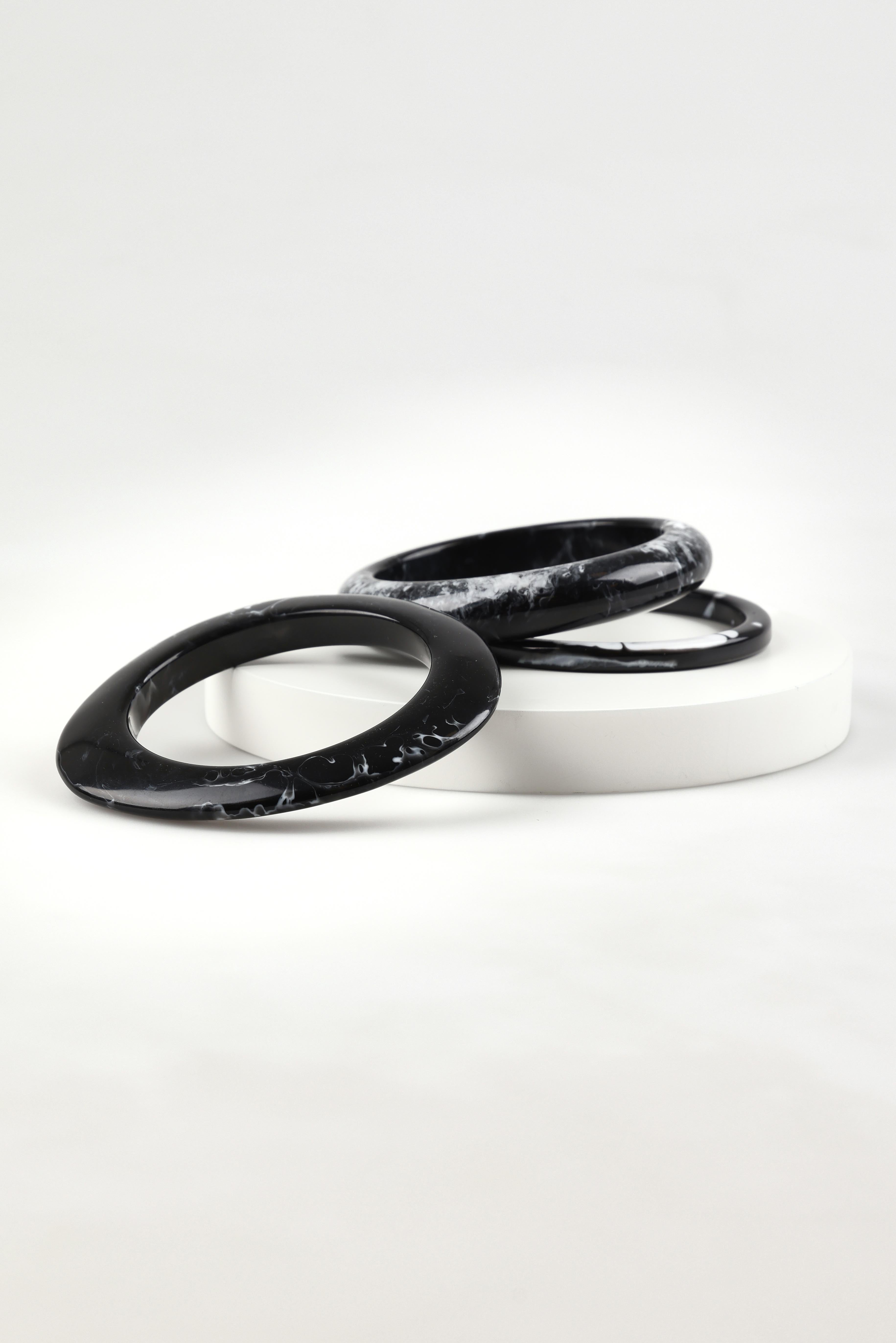A model wearing the Highway Bangle in colour Blkmarble (Black), from the front, showing the whole outfit