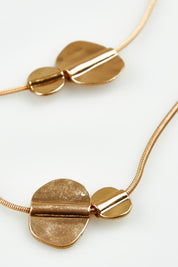A model wearing the Toronto Necklace in colour Gold (Metallics), from the front, showing the whole outfit