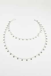 A model wearing the Cosmos Necklace in colour Silver (Metallics), from the front, showing the whole outfit