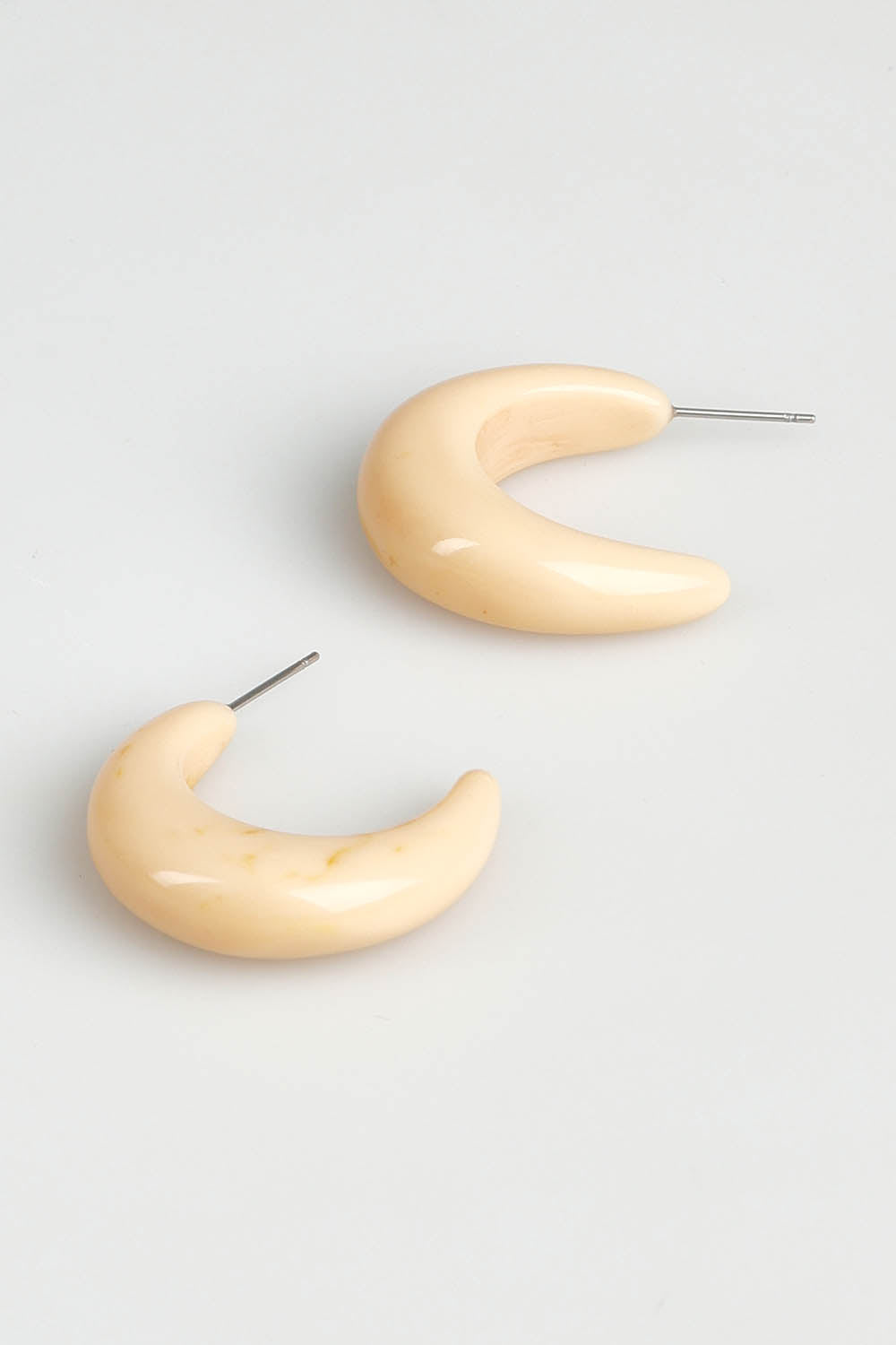 A model wearing the Swerve Earring in colour Natural, from the front, showing the whole outfit