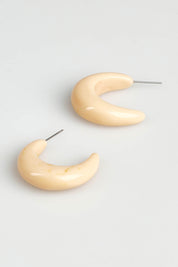 A model wearing the Swerve Earring in colour Natural, from the front, showing the whole outfit