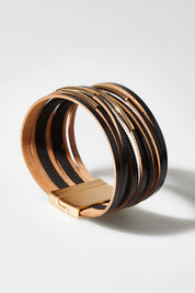A model wearing size OneSize of the Ainsley Bracelet in colour Blackgold (Black), from the front, showing the whole outfit