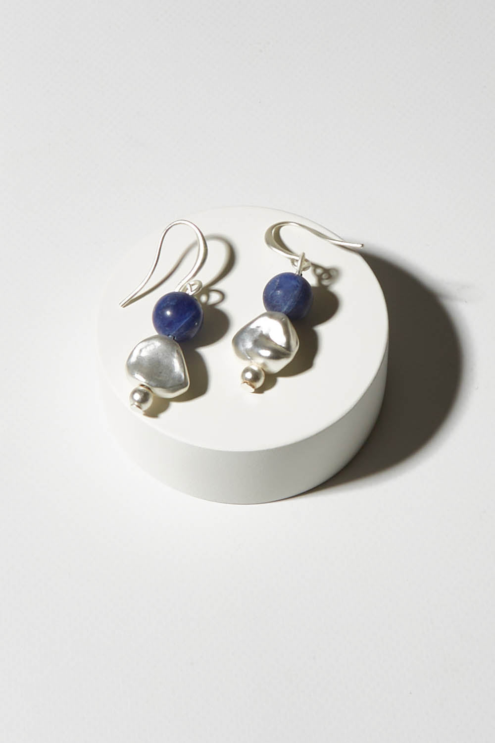 A model wearing size OneSize of the Binnie Earrings in colour Navysilv (Blue), from the front, showing the whole outfit